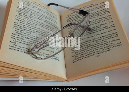 Gläser auf ein offenes Buch liegend Stockfoto