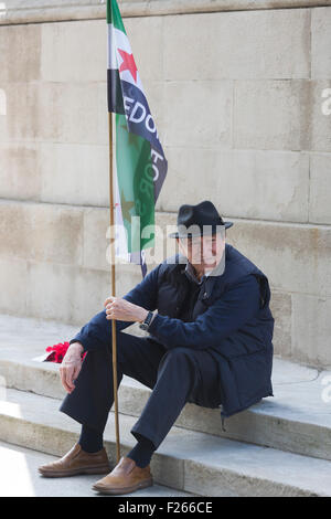 London, UK. 12. September 2015.  Ein syrischer Mann sitzt auf den Stufen des Cenotaph in Whitehall. Zehntausende von Menschen beteiligen sich die Solidarität mit Flüchtlingen Demonstration im Zentrum von London fordert David Cameron, wirksame Maßnahmen zu ergreifen die Flüchtlingskrise umdrehen und Großbritanniens Anteil der Flüchtlinge bereits in Europa zu akzeptieren. Lebendige Bilder/Alamy Live-Nachrichten Stockfoto