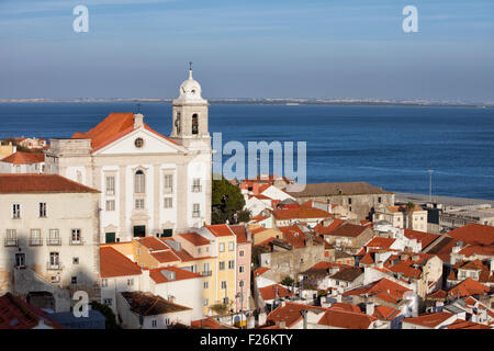 Stadt von Lissabon in Portugal, Blick über Alfama Viertel Santo Estevao Kirche und Tejo im Hintergrund. Stockfoto