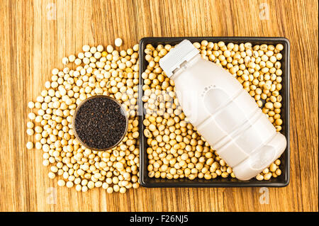 Soja und Soja-Milch mit schwarzem Sesam auf Holztisch Stockfoto