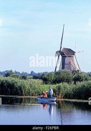 Zwei lokale Männer Angeln auf dem Deich wind eine Windmühle auf der Rückseite, Kinderdijk, Holland, Niederlande, Europa. Stockfoto