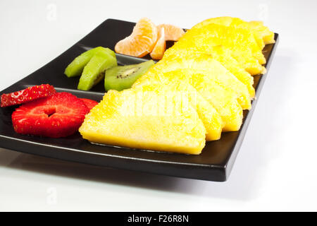 Geschnittene Früchte auf schwarz Untertasse Stockfoto