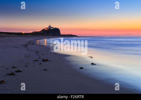 Berühmte Nobbys Kopf und Leuchtturm in Newcastle Australien bei Sonnenaufgang vom Sandstrand Stockfoto