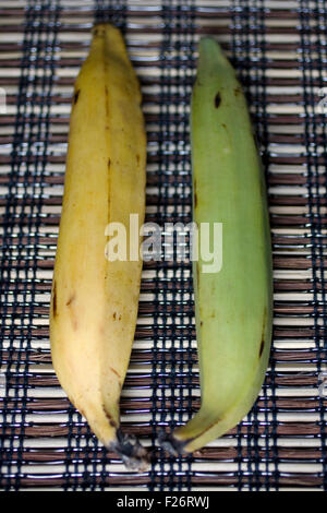 Grüne und gelbe Bananen auf placemet Stockfoto