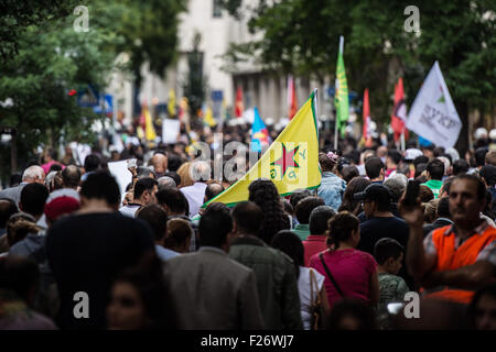 Ein Teilnehmer an einer Kundgebung gegen die Politik der türkischen Regierung, trägt eine Flagge des so genannten "Peoples Schutz Einheiten" (YPG), die wichtigsten bewaffneten Dienst der kurdischen Supreme Committee, der Regierung der Syrisch-Kurdistan, wie sie marschiert durch die Straßen von Stuttgart, Deutschland, 12. September 2015. Einige 2.000 Kurden und der türkischen Regierung, die Kritiker auf die Straße gingen, um die eskalierende Spannung in ihrem Land zu protestieren, nachdem eine Welle von Luftangriffen gegen die kurdische Arbeiterpartei (PKK) Ziele im Nordirak Türkei durchgeführt. Foto: Wolfram Kastl/dpa Stockfoto