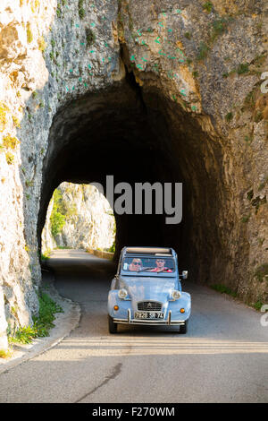 Citroen 2CV Autofahrer fahren, Klettern durch eine Alpentunnel / pass (Col De La Chambotte) in den französischen Alpen. Frankreich Stockfoto