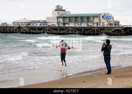 Bournemouth, Dorset, UK 13. September 2015. Junge Frau in die Luft springen, während Mann Foto von ihr am Strand von Bournemouth im September stattfindet. Bildnachweis: Carolyn Jenkins/Alamy Live-Nachrichten Stockfoto