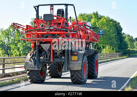 Bauer fahren Sam selbstfahrende Feldspritze mit Hochkonjunktur in der Kreuzung der Autobahn Land Lane schmale Straße Brücke Essex England UK gefaltet Stockfoto