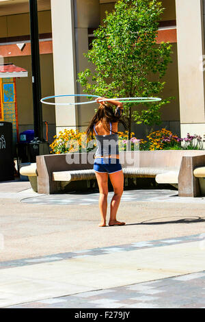 Ein College-Mädchen üben Sie ihre Fähigkeiten mit einem Hoola-Hoop in der Innenstadt von Madison Wisconsin Stockfoto