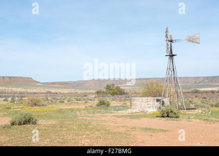 GANNABOS, Südafrika - 11. August 2015: ein typischer Bauernhof Szene mit einer Wasserförderung Windmühle und dam. Stockfoto