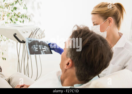 Zahnärztin, die Diskussion über ein Röntgen-Bericht mit Patienten, München, Bayern, Deutschland Stockfoto