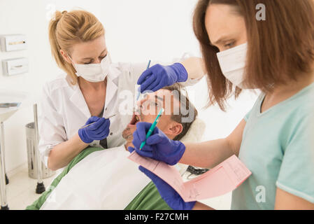 Zahnärztin Patienten und diktiert die Ergebnisse an den Assistenten, München, Bayern, Deutschland Stockfoto