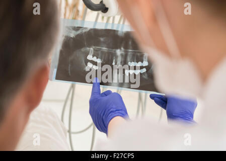 Zahnarzt diskutieren einen Röntgen-Bericht mit Patienten, München, Bayern, Deutschland Stockfoto