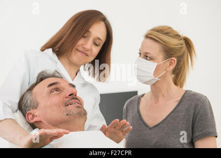 Zahnärztin tröstet Patienten mit Zahnarzthelferin, München, Bayern, Deutschland Stockfoto