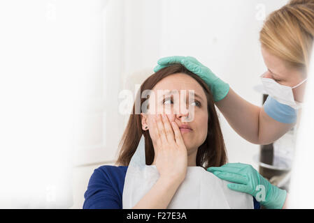 Ärztin, tröstet Patienten leiden Zahnschmerzen, München, Bayern, Deutschland Stockfoto