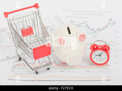 Warenkorb mit Sparschwein und Uhr Stockfoto