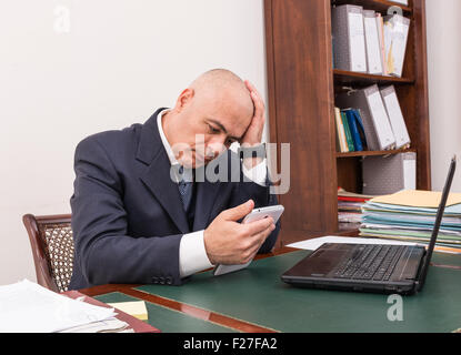 Der Mann am Schreibtisch, betrachten Sie Ihre i Pad/Tablet, in seinem Büro. Stockfoto