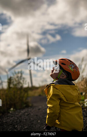EAGLESHAM, Schottland - AUGUST 28: einen allgemeinen Überblick über ein junges männliches Kind Radfahren auf einem Radweg unter Windkraftanlagen auf Schottisch Stockfoto