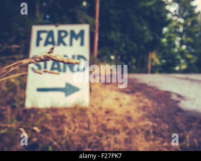 Rustikale Zeichen für eine Farm stehen am Straßenrand Stockfoto