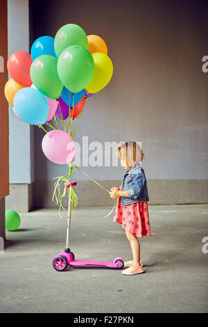 glückliche kleine Mädchen im Freien mit Luftballons Stockfoto