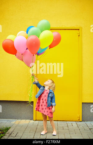 glückliche kleine Mädchen im Freien mit Luftballons Stockfoto
