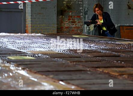 Brüssel, Belgien. 13. Sep, 2015. Eine Frau nimmt Fotos von einer riesigen Schokolade in einer Schokoladenfabrik in Tongeren, Belgien, 13. September 2015. Die Fabrik produzierte Schokolade, 21 Meter lang, 5 Meter in der Breite und 1000 kg Gewicht und legte es auf Anzeige am Sonntag, im Rahmen des belgischen Heritage Days. © Gong Bing/Xinhua/Alamy Live-Nachrichten Stockfoto