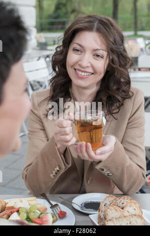 Zwei Freundinnen reden und Tee in Bürgersteig Café, Bayern, Deutschland Stockfoto