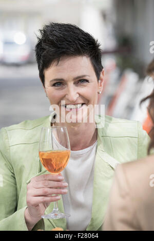 Zwei Freunde trinken Aperol Spritzat am Bürgersteig Café, Bayern, Deutschland Stockfoto