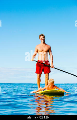 Vater und Sohn Stand Up Paddeln. Spaß im Freien. Sommer Lifestyle. Stockfoto