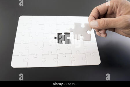 Hand, die Platzierung der letzten Stück in Jigsaw Puzzle, Bayern, Deutschland Stockfoto