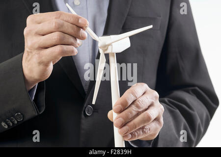 Geschäftsmann untersucht Windkraftanlagenmodell, Bayern, Deutschland Stockfoto