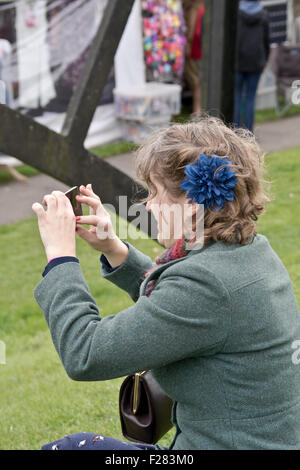 Schüren Sie Bruerne, Dorf im Krieg 1940 eine Dame ein Bild auf ihrem nimmt Telefon © Scott Carruthers / Stockfoto