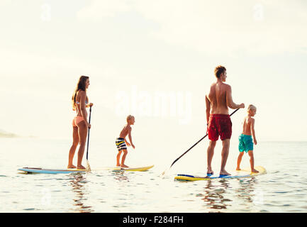 Familie mit Spaß Stand Up Paddling zusammen im Ozean an schönen sonnigen Morgen Stockfoto