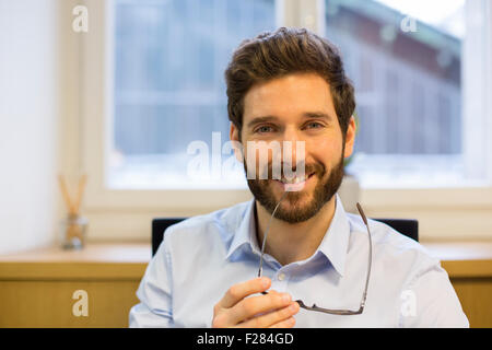 Porträt des Mannes sitzt an seinem Schreibtisch im Büro Stockfoto