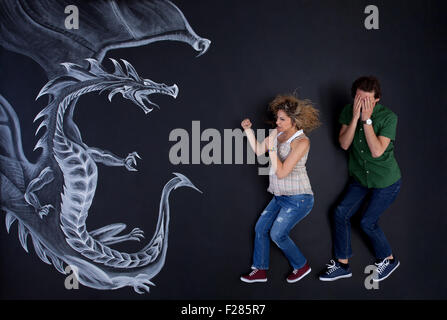 Junge schwangere Frau seinen Mann gegen eine Zeichnung Drachen zu schützen. Stockfoto