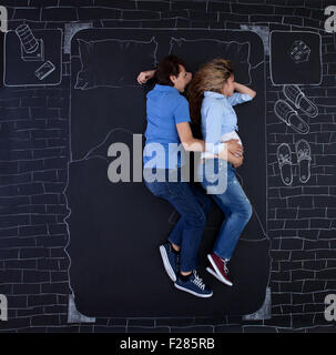 Junges Paar im Bett schlafen, umarmt Hand in Hand, der Mann seiner Frau. Junger Vater mit einer Hand auf Mamas Bauch schlafen. Stockfoto
