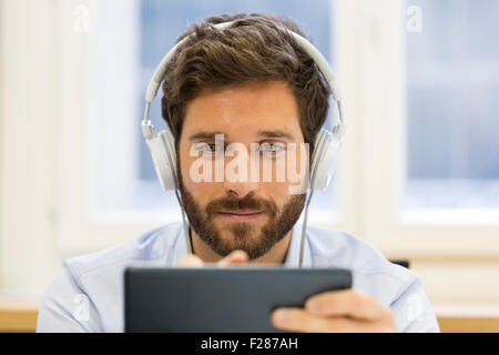 Porträt des bärtigen Geschäftsmann Musik hören auf TabletPC Stockfoto