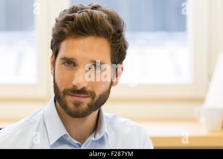 Porträt des bärtigen Geschäftsmann im Büro Kamera suchen. Stockfoto