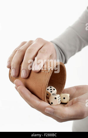 Frau Gießen Würfel in der Hand von Würfelbecher, Bayern, Deutschland Stockfoto