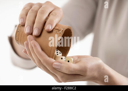 Frau Gießen Würfel in der Hand von Würfelbecher, Bayern, Deutschland Stockfoto