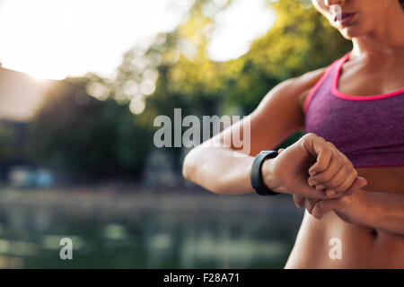 Frau die Fitness smart Watch für den Betrieb einrichten. Watch Prüfeinrichtung Sportlerin. Stockfoto