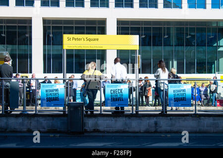 St.-Peters-Platz Straßenbahn (Metrolink) Haltestelle im Zentrum von Manchester. Pendler und Personal, die Straßenbahn warten. Sonniges Wetter. Stockfoto