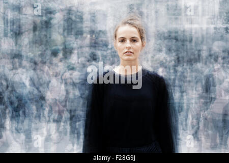 Frau, umgeben von einer geschäftigen Menge von Menschen zu bewegen Stockfoto