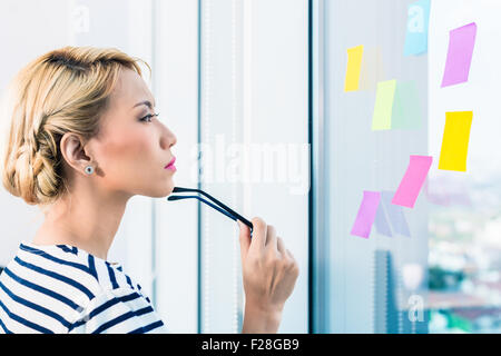 Chinesische Business-Frau, Planung und Organisation mit Aufklebern Stockfoto