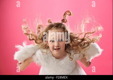 Schöne kleine Engel Mädchen auf rosa Hintergrund isoliert Stockfoto