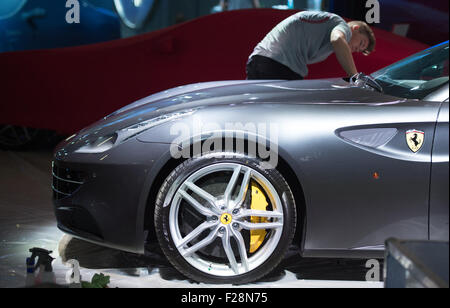 Ein Bediensteter Polituren einen Ferrari auf der International Motor Show Deutschland (IAA) in Frankfurt/Main, Deutschland, 14. September 2015. Hersteller aus aller Welt präsentieren ihre Neuheiten vom 17. bis 27. September 2015. Foto: Boris Roessler/dpa Stockfoto