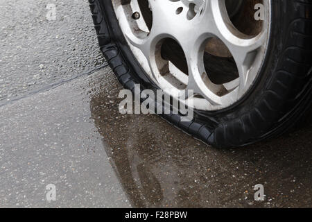 Reifenpanne auf nasser Fahrbahn Stockfoto