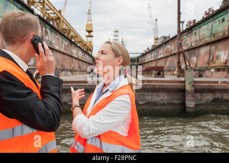 Zwei Geschäftsleute diskutieren am Hafen, Hamburg, Deutschland Stockfoto
