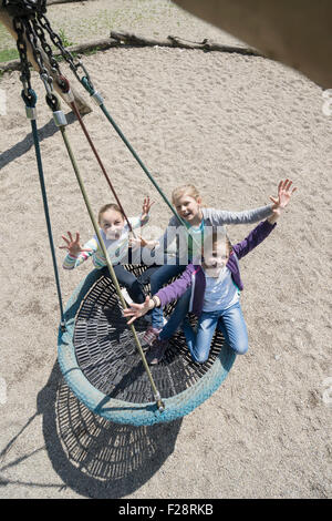Erhöhte Ansicht von Mädchen schwingen auf einer Schaukel Spielplatz, München, Bayern, Deutschland Stockfoto