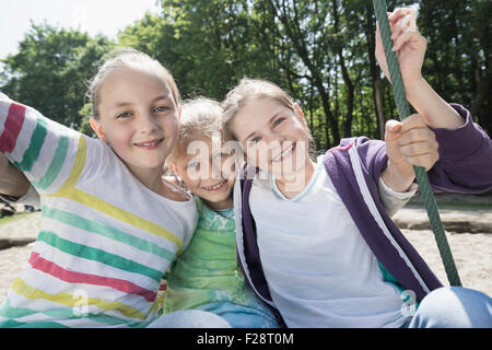Mädchen schwingen auf einer Schaukel Spielplatz, München, Bayern, Deutschland Stockfoto
